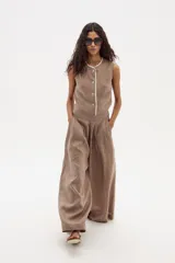 Pantalón palazzo color marrón claro, de tiro alto y confeccionado en lino.