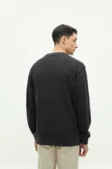 Buzo negro de felpa con logo estampado y costuras externas.