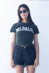 Remera corta verde musgo con cuello redondo y estampado frontal con la palabra 'DELOALTO' en letras blancas.