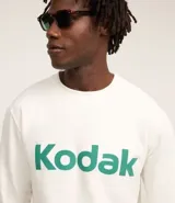 Buzo blanco de algodón y poliéster con cuello redondo y mangas largas. Estampa frontal con la palabra "Kodak" en color verde.