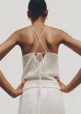 Top tejido al crochet color rosado, con cuello halter y tirantes finos.