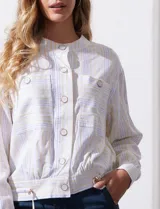 Chaqueta de lino a rayas verticales amarillas y celestes, con cuello a la base, abertura central con botones, bolsillos delanteros y ruedo con jareta de ajuste.