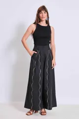 Pantalón negro de tiro alto y corte palazzo, con detalle de strass plateado en forma de ondas verticales.