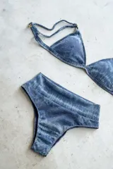 Conjunto de bikini azul con estampado difuminado. Incluye corpiño de triángulo fijo con breteles regulables y almohadillas desmontables, y bombacha vedetina de tiro alto.