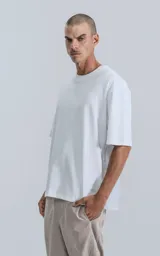 Remera blanca de algodón con corte crop, calce oversize, hombros caídos y cuello redondo.