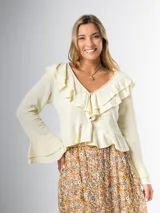 Blusa color amarillo claro en lino rayón con volados, de mangas largas acampanadas y cierre frontal con botones.