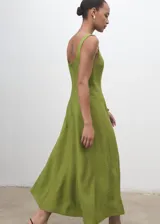 Vestido midi color verde lima, sin mangas, con escote cuadrado y tirantes anchos. Presenta un diseño evasé con costuras decorativas verticales y cierre de cremallera en la espalda.
