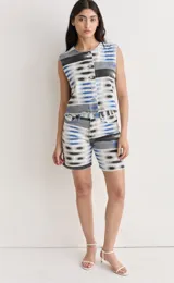 Bermuda de denim con estampado de círculos concéntricos en tonos azul, gris y blanco.