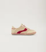 Championes de cuero color beige con detalles en rojo, suela de yute y cordones con diseño trenzado.
