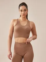 Top deportivo gris oscuro con espalda deportiva y banda elástica en el bajo busto.