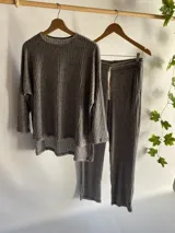 Conjunto gris de lanilla rib, compuesto por un buzo de corte holgado con mangas 3/4 y un pantalón recto con bolsillos y cordón ajustable en la cintura.