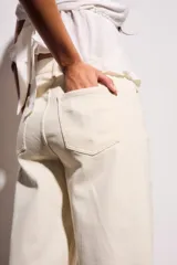 Jean de mujer color crema o blanco roto, de corte baggy y tiro medio. Confeccionado en algodón con un pequeño porcentaje de elastano.