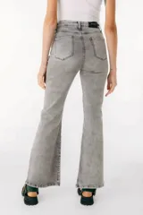 Pantalón de jean azul de corte acampanado con aberturas en el ruedo.
