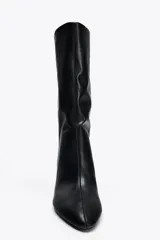 Bota de cuero sintético negro con efecto arrugado, terminación en punta y tacón fino.