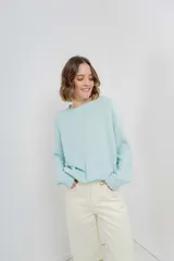 Sweater azul de punto medio, amplio, suave, con escote a la base y puños en mangas y en acabado inferior.