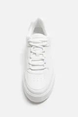 Zapatillas deportivas blancas de estilo retro con suela de plataforma.
