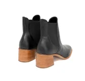Botín negro de cuero con paneles laterales elásticos, punta ligeramente cuadrada y tacón de bloque de madera.