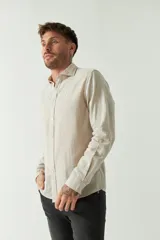 Camisa de manga larga color amarillo claro, confeccionada en lino y algodón, corte semi slim y logo bordado.