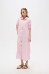 Vestido camisero midi negro de corte holgado, con cuello camisero, mangas cortas con trabillas, cierre frontal con botones, bolsillo en el pecho y bolsillos laterales.