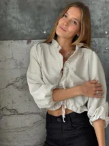 Blusa color blanco de lino, con mangas 3/4 y volados en el frente. Se ata con lazos en el centro.