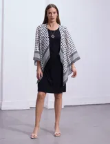 Conjunto de vestido negro sin mangas y chaqueta estampada con terminación asimétrica, marca Sandra Darren.