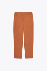 Pantalón color crema de tiro alto con pinzas delanteras y cintura elástica en la espalda. Tiene bolsillos delanteros y traseros.