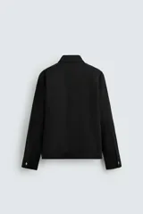 Sobrecamisa color arena de corte relaxed fit, confeccionada en tejido con mezcla de algodón. Tiene cuello solapa, manga larga con puños abotonados, bolsillos de plastrón con solapa en el pecho y bolsillos laterales en la costura de la cadera. El cierre es frontal con cremallera.
