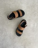 Sandalias con plataforma color marrón con textura de piel de reptil, con dos tiras anchas sobre el empeine y tira trasera ajustable.