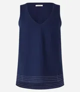 Musculosa en piquet color verde oliva, con escote en pico, breteles anchos, pequeñas aberturas laterales y bajos con pespuntes.