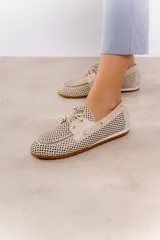 Náuticos color beige con diseño calado geométrico, cordones decorativos y suela marrón.