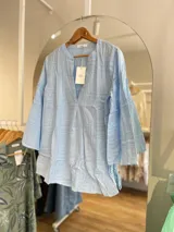Blusa blanca de algodón con bordado tipo broderie, escote en V y mangas 3/4.