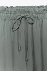 Pantalón de tiro medio con cintura elástica ajustable con cordones, de pierna ancha y bolsillos laterales ocultos en costura. Confeccionado en hilatura con mezcla de lyocell.