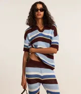 Pantalón femenino de punto con efecto crochet, de corte flare, cintura elástica y rayas horizontales en diferentes anchos y colores (azul claro, azul medio, bordó y blanco).