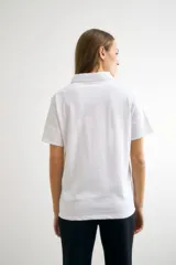 Remera azul marino de algodón con cuello polo, manga corta con detalle de broderie y tapeta con botones.