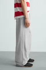 Pantalón jogger wide fit negro confeccionado en tejido de algodón con interior rizo. Pernera ancha, cintura elástica ajustable con cordón interior, bolsillos laterales y bolsillo trasero de plastrón.