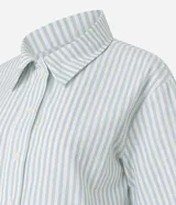 Camisa corta de sarga a rayas verticales celestes y blancas, con cuello inglés, mangas cortas y abotonadura frontal.