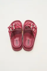 Sandalia tipo birkenstock de color negro, con dos tiras ajustables con hebillas metálicas plateadas. Las tiras están decoradas con tachas plateadas.