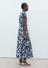Vestido largo de manga corta con estampado de hojas en azul marino y blanco. Presenta escote de pico, fruncido ajustable en la cintura y corte evasé.