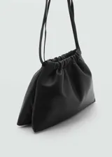 Bolso de hombro negro de cuero con fruncido superior y asa ajustable con hebilla.