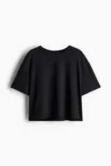 Remera deportiva corta de corte holgado, color negro, con cuello redondo y mangas cortas con hombros caídos.