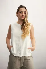 Blusa color crema sin mangas, de lino, con cuello redondo y corte recto.