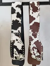 Faja ancha con estampado de vaca, con hebilla metálica y tachas decorativas.