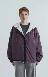 Campera reversible con cierre. Un lado de tela corderito color crudo y otro de tela tipo bomber color negro.