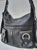 Cartera bandolera negra con múltiples bolsillos frontales con cierre y hebillas decorativas.