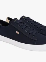 Zapatillas Tommy Hilfiger de lona azul marino con suela blanca de goma y talón dorado metalizado.