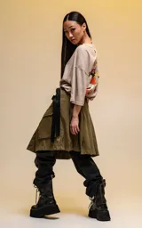 Remera oversize de algodón premium color beige, con cuello redondo y manga corta. Presenta un estampado central de Mickey Mouse en una pose dinámica.