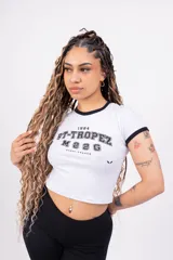 Remera corta de jersey color rosa con cuello redondo y mangas cortas con ribete blanco. Estampado frontal con la inscripción "ST-TROPEZ" en letras blancas.