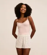 Blusa de pijama blanca de bretel fino con encaje en el escote y textura acanalada.