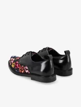 Mocasín negro con adornos de flores en tonos multicolor y punta cuadrada.