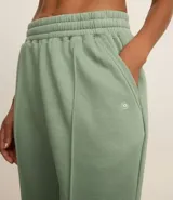 Pantalón deportivo color morado, de algodón y poliéster, con cintura elástica y bolsillos laterales.